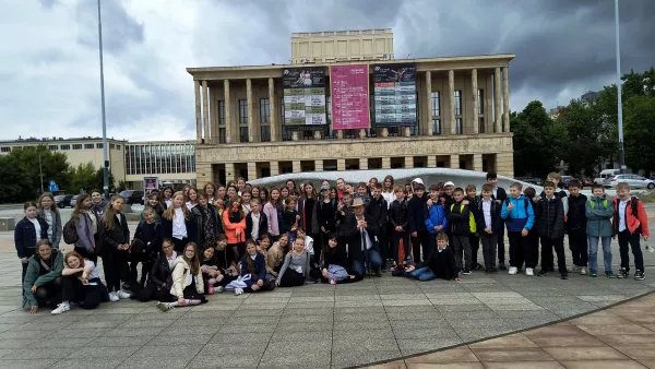 Zdjęcie grupowe klas obecnych na przedstawieniu operowym Przygody Pinokia przed Teatrem Wielkim
