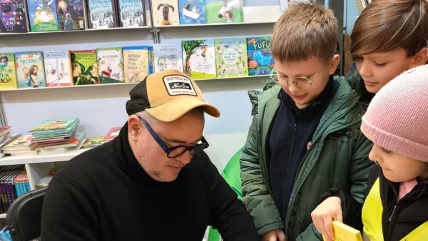 Pan Grzegorz Kasdepke podpisuje książkę. 