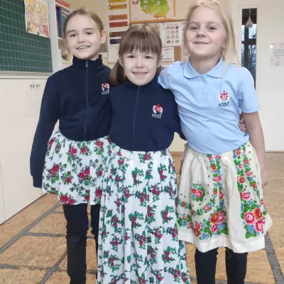 Dziewczynki z klasy 1a SSP obejmujące się za ramiona i pozujące do zdjęcia w spódnicach góralskich 