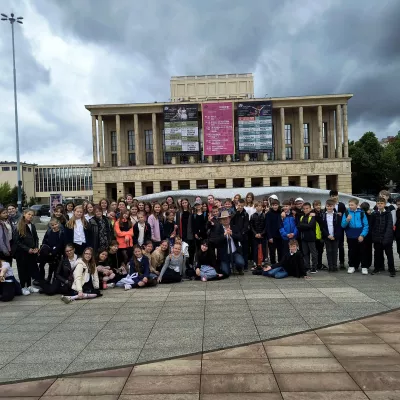 Zdjęcie grupowe klas obecnych na przedstawieniu operowym Przygody Pinokia przed Teatrem Wielkim