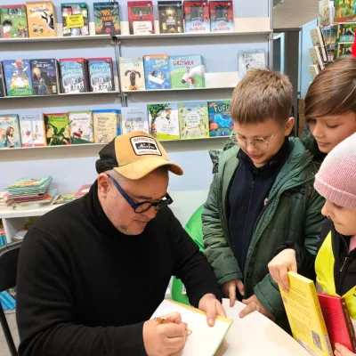 Pan Grzegorz Kasdepke podpisuje książkę. 