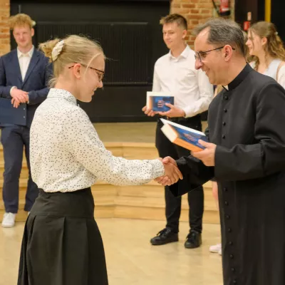 Ks. Dyrektor wręcza licealistom świadectwa z wyróżnieniem. (fot. Amelia Szymańska)