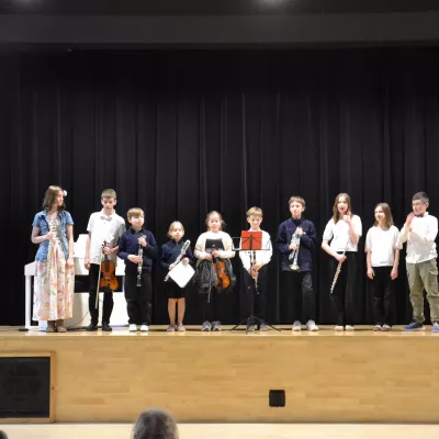 Zdjęcie grupowe artystów po występie dla uczniów klas 1-3 razem z prowadzącą nauczycielką. 