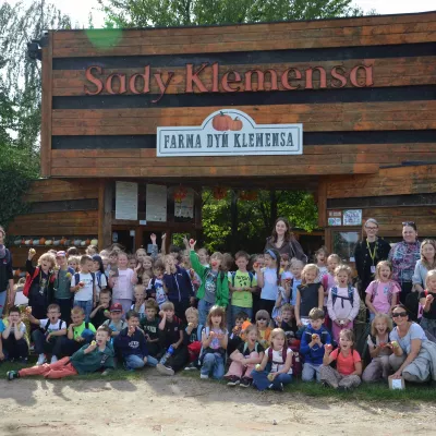 Zdjęcie grupowe pierwszoklasistów przed bramą Sadów Klemensa.  