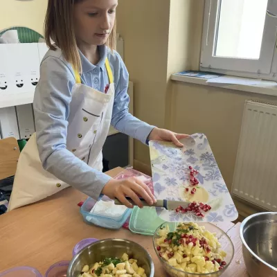 Uczennica przygotowuje sałatkę owocową.