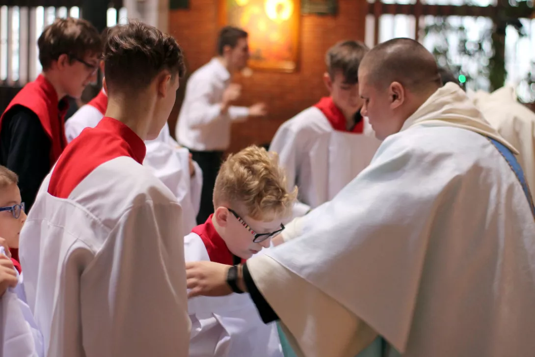Nałożenie stroju ministranta. (fot. Mateusz Ociński)