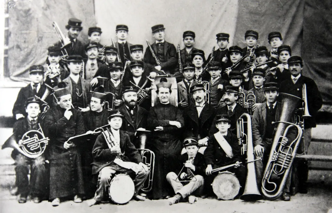 Ksiądz Bosko z orkiestrą. Na zdjęciu są uczniowie i nauczyciele szkoły muzycznej z oratorium na Valdocco. Fotografia z roku 1870 r.