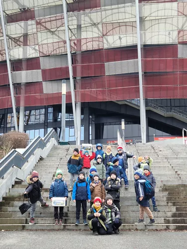 Uczniowie klasy 2D przed Stadionem Narodowym pozujący do zdjęcia.