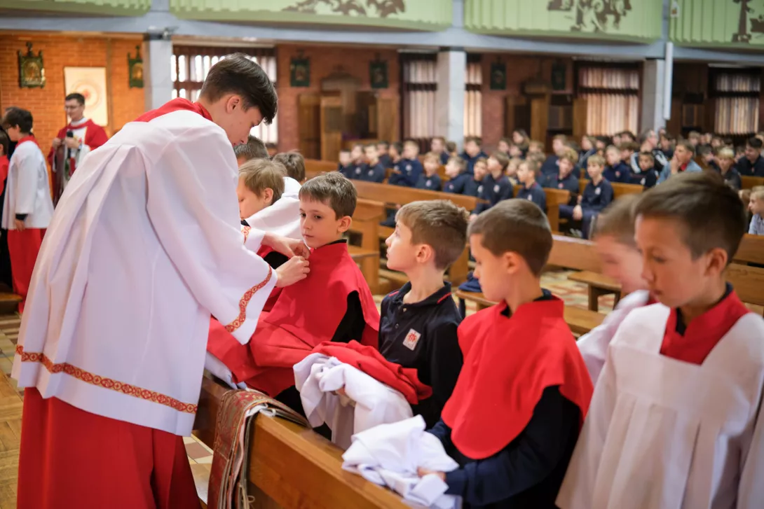 Nowi ministranci otrzymują peleryny i komże.