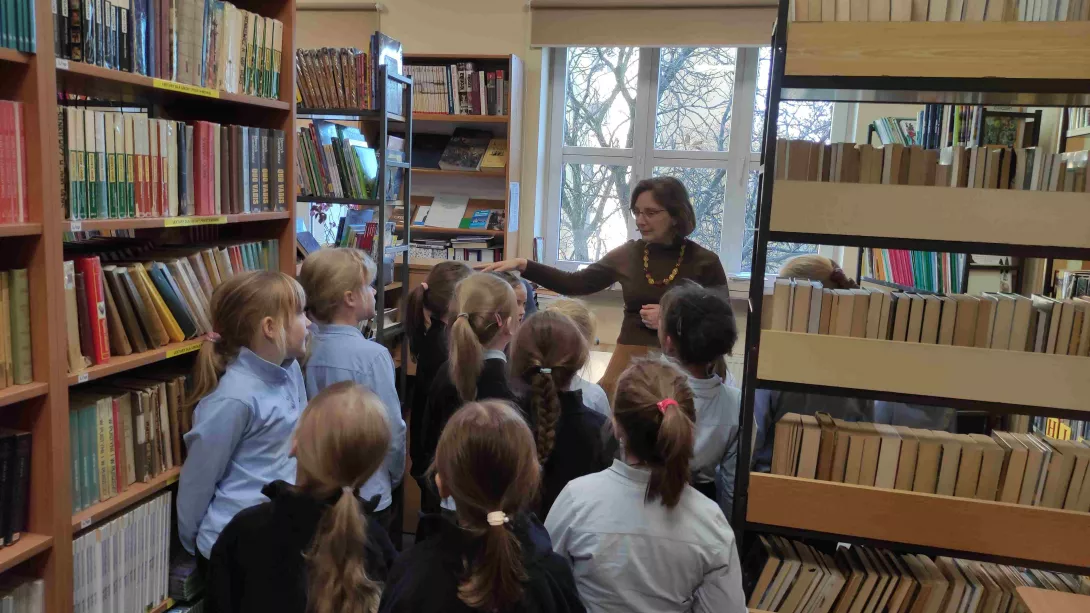 Dziewczynki z klasy 1a SSP uczestniczą w lekcji bibliotecznej prowadzonej przez nauczyciela bibliotekarza