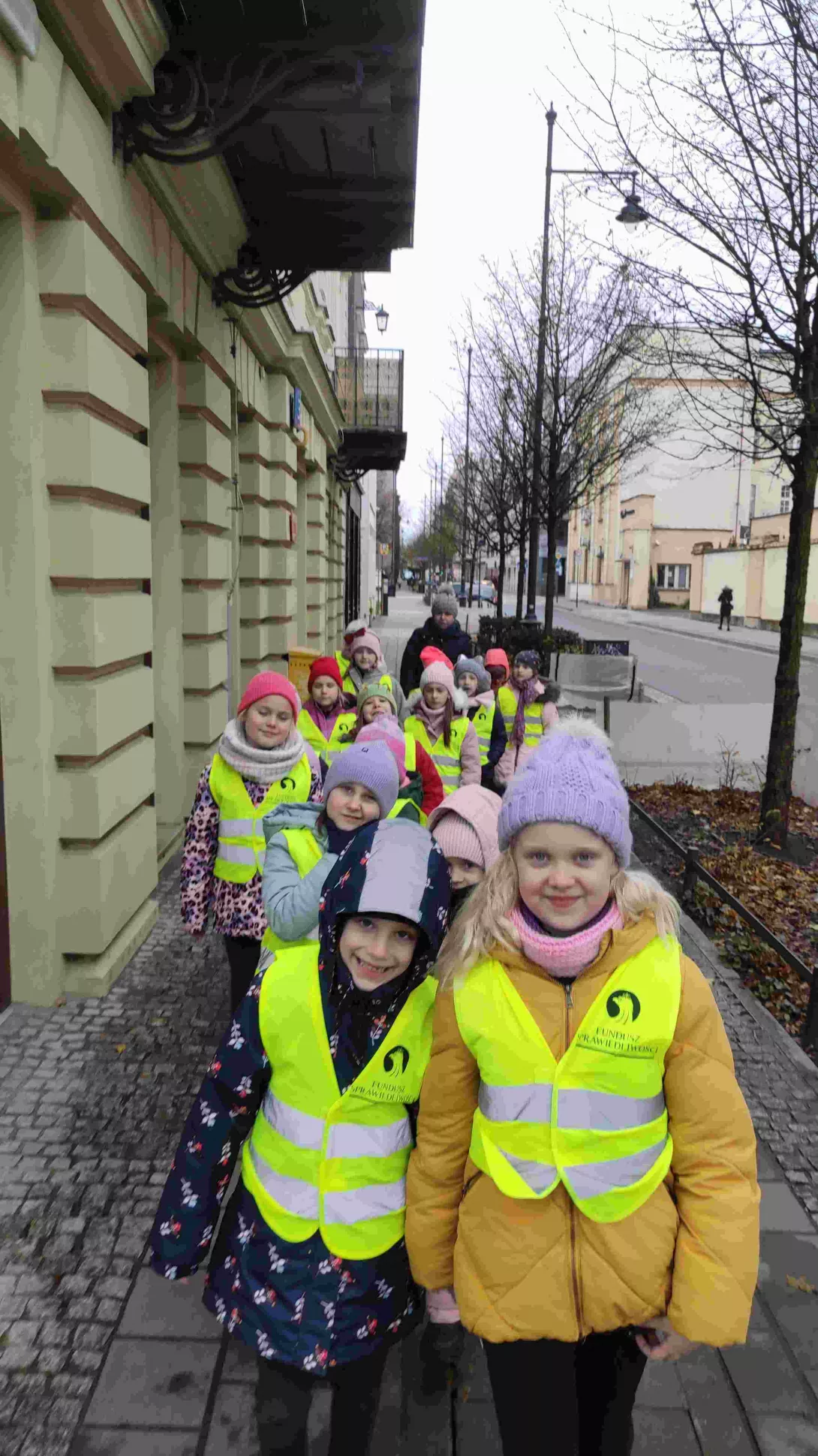 Klasa 1a SSP maszerująca chodnikiem w drodze do TUVIM Biblioteka Miejska filia nr 63