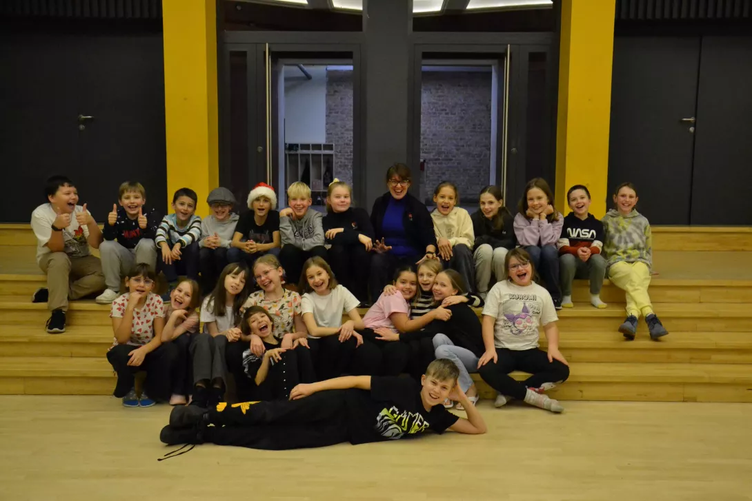 Grupa uczniów teatru Beznazwy w auli szkolnej.