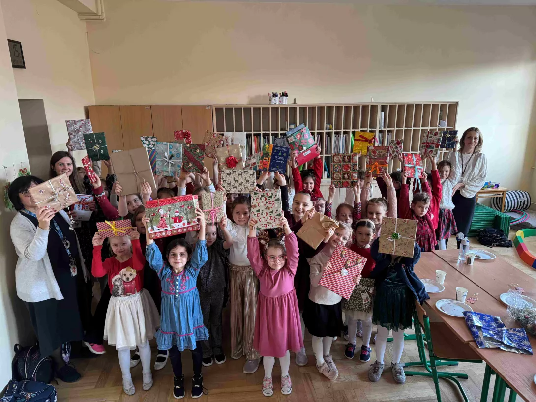 Wigilie klas wczesnoszkolnych. Klasa 1a i 1c obdarowująca się książkowymi prezentami.
