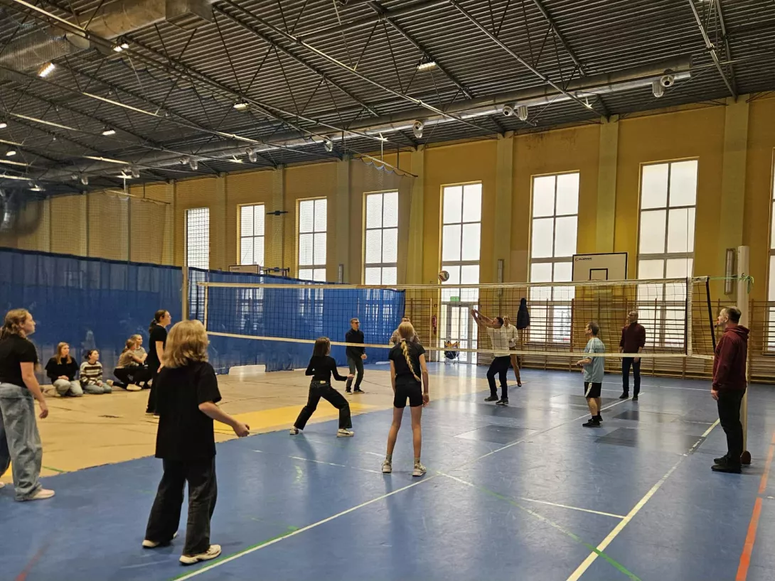 Uczniowie z rodzicami grają w siatkówkę