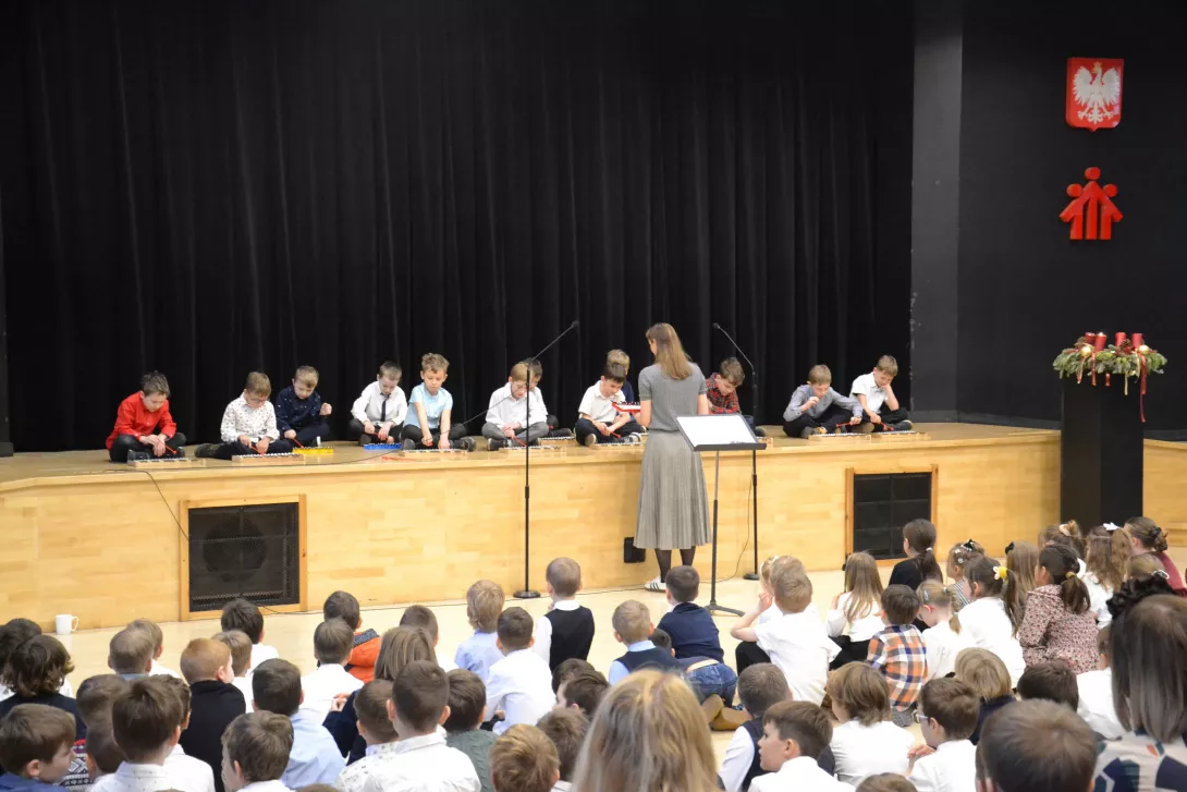 Uczniowie klasy 2d grający na dzwonkach w czasie świątecznej uroczystości klas wczesnoszkolnych. 