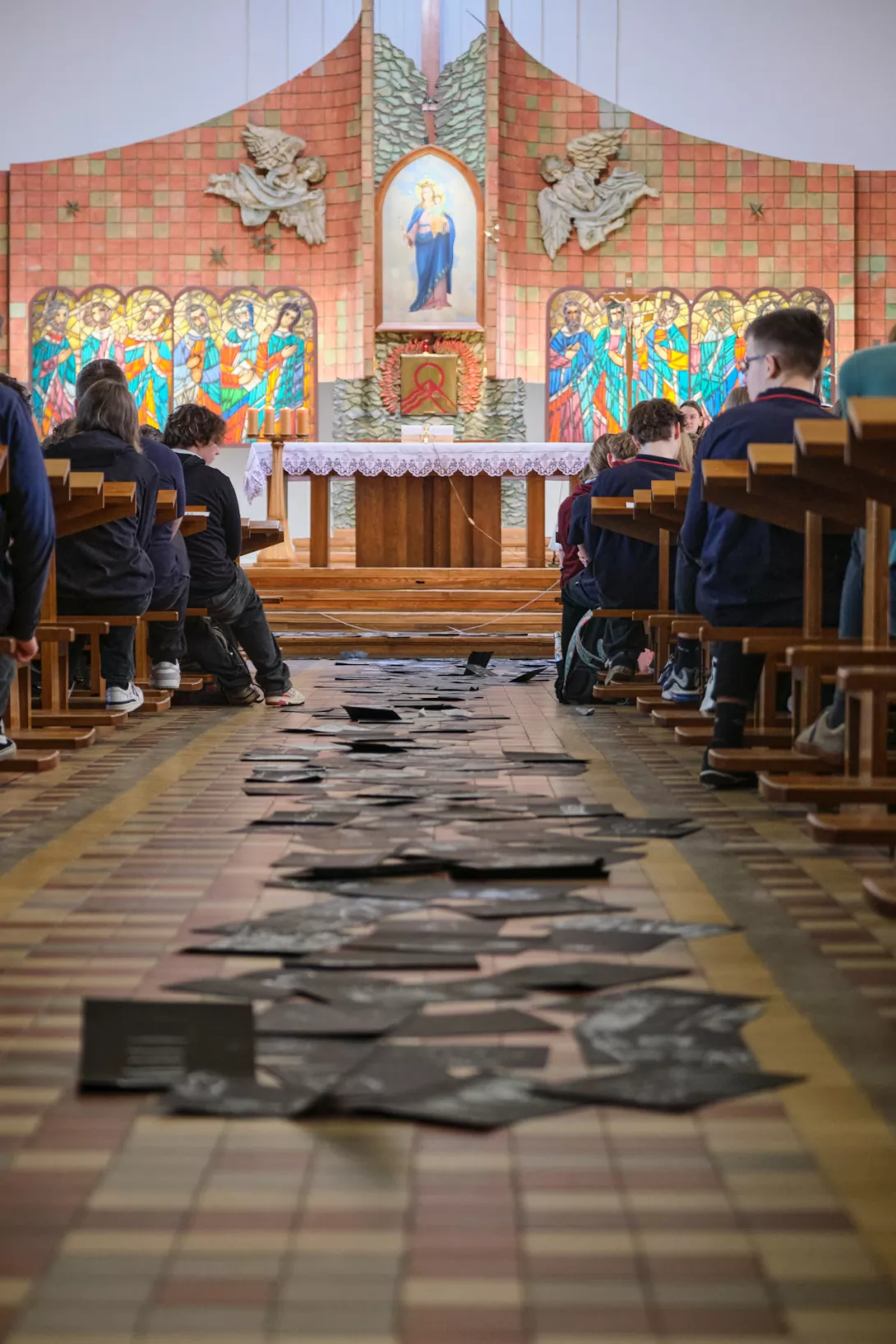 Symboliczna „ciemna dolina” ułożona z czarnych kartek przez środek kościoła. (fot. Maciej Majtczak)