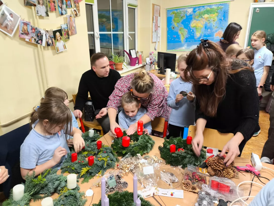 Uczennice wraz z rodzicami przygotowują wieńce adwentowe