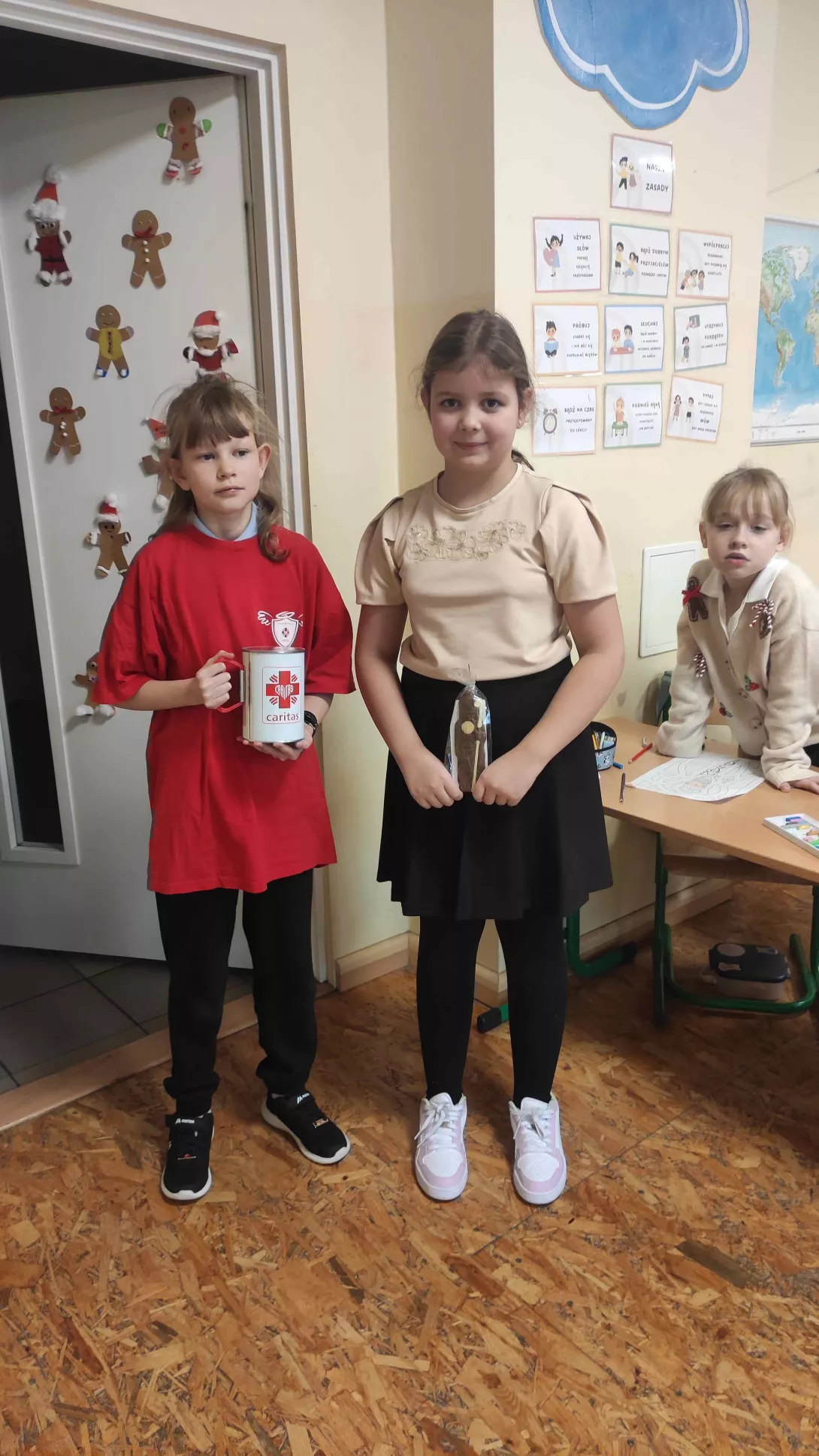 Wolontariuszka SKC wraz z uczennicą SSP podczas szkolnej akcji charytatywnej Czekoladowy Mikołaj 5 grudnia 2025