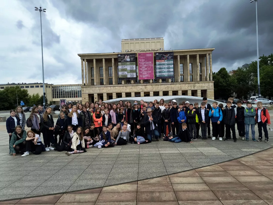 Zdjęcie grupowe klas obecnych na przedstawieniu operowym Przygody Pinokia przed Teatrem Wielkim