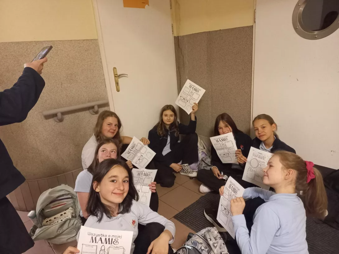 Uczennice pokazują karty pracy dla swoich mam