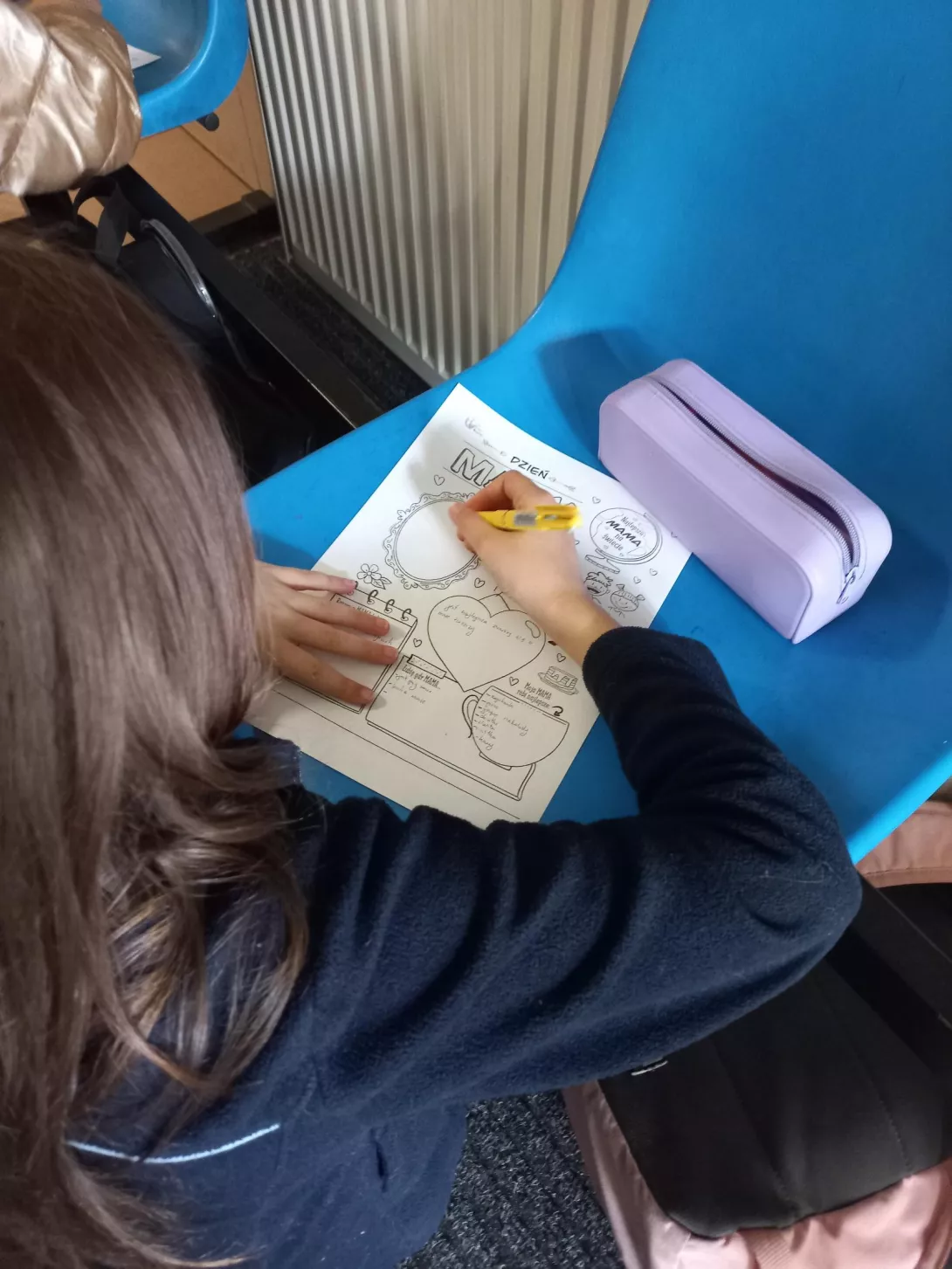 Uczennica wypełnia kartę pracy dla swojej mamy