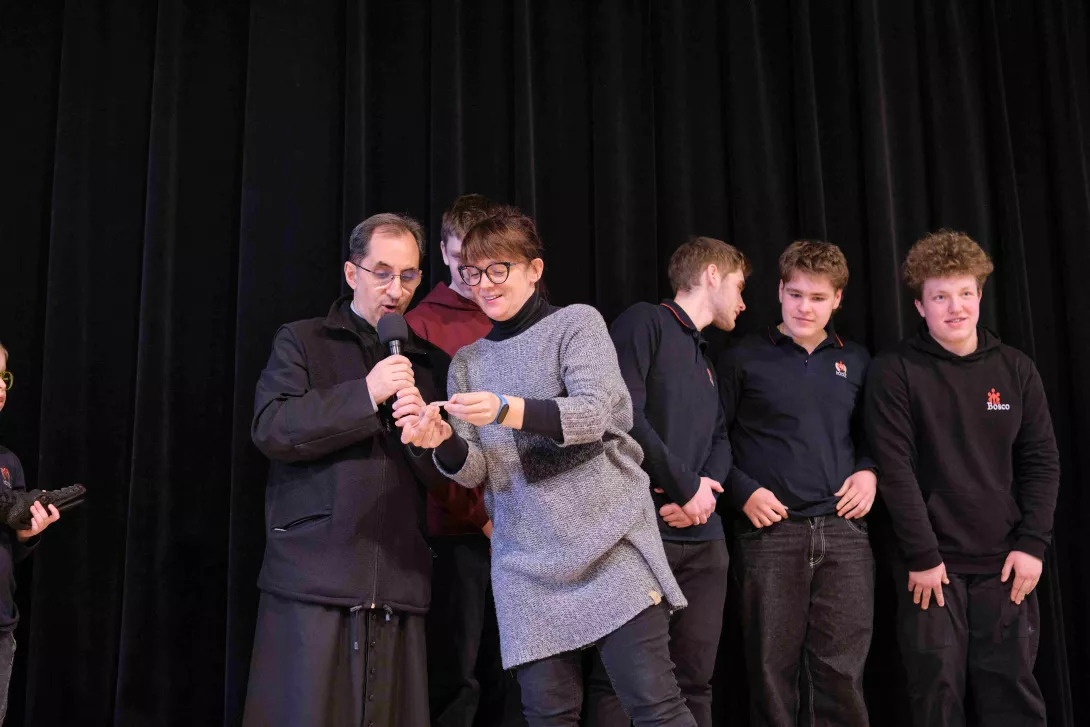 Ksiądz Dyrektor Robert Bednarski odczytuje nazwisko ucznia, który zdobył główną nagrodę w loterii misyjnej. 