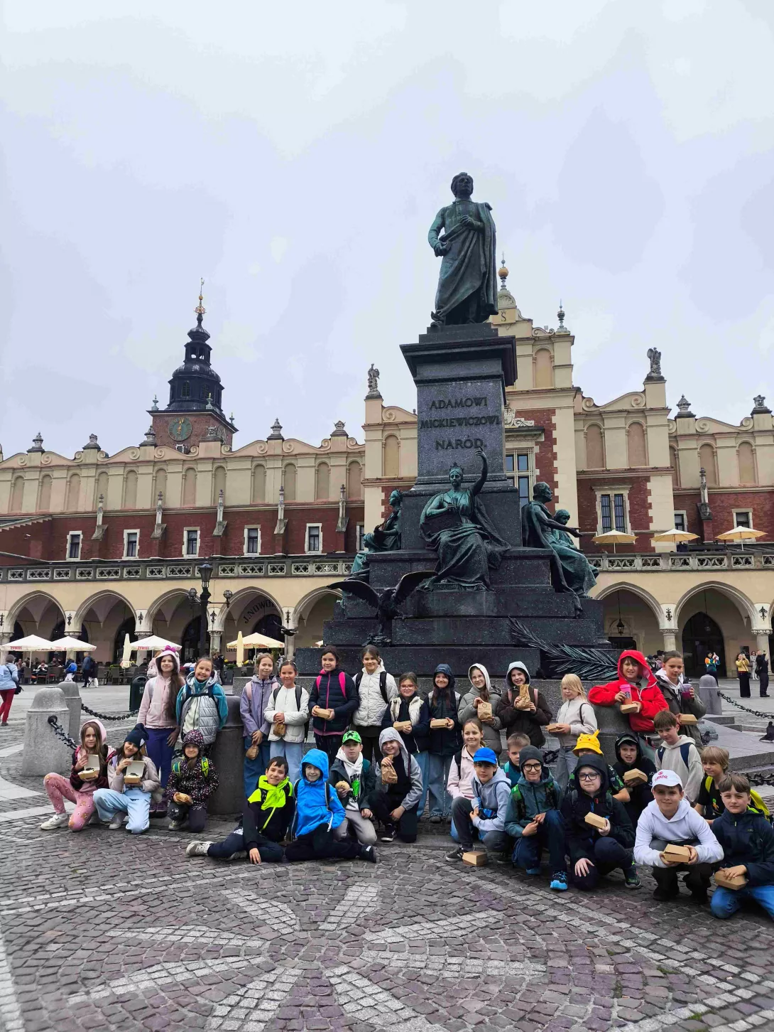 Zdjęcie grupowe klasy 3a i 3b w czasie wycieczki do Krakowa. Stary Rynek i Sukiennice. 