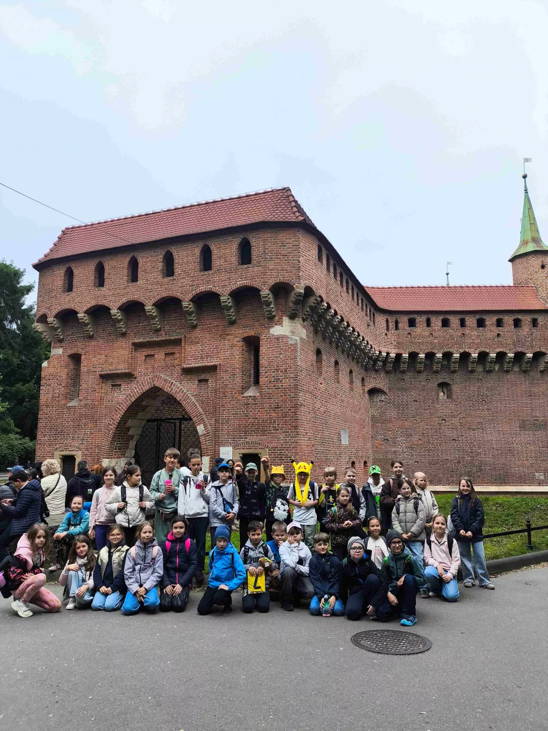 Zdjęcie grupowe klasy 3a i 3b w czasie wycieczki do Krakowa. W tle Barbakan. 