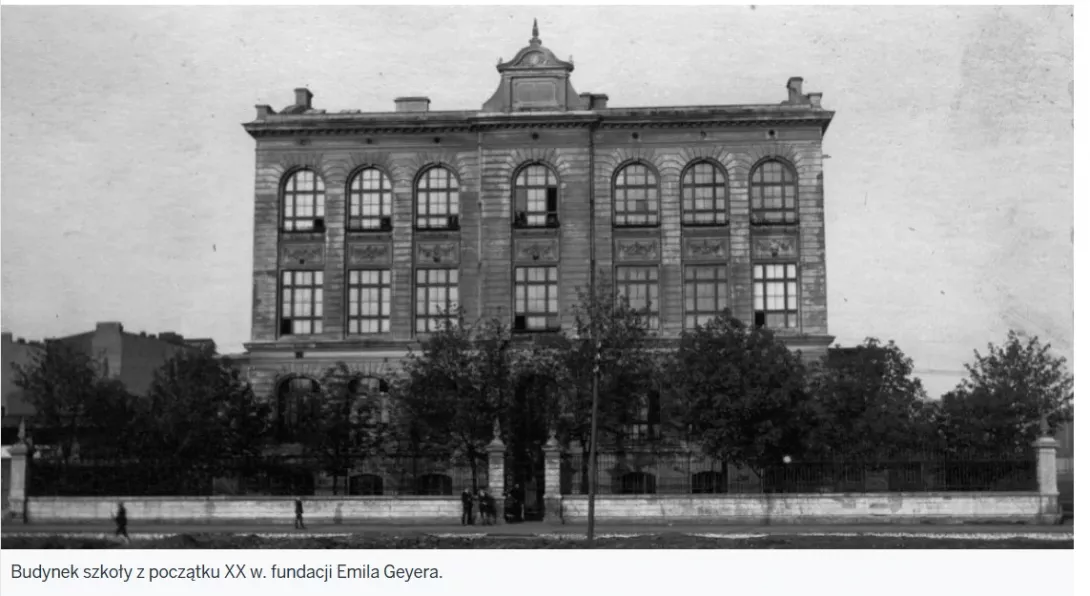 Czarno-białe zdjęcie przedstawia okazały, murowany budynek szkoły z początku XX wieku, o symetrycznej fasadzie i wysokich, łukowych oknach. Obiekt otoczony jest ogrodzeniem i drzewami, a przed nim widać przechodniów; szkoła została ufundowana przez Emila Geyera.