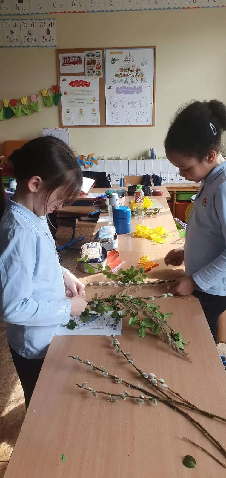 Dziewczynki z klasy 2a SSP podczas warsztatów robienia palm wielkanocnych w czasie świetlicy