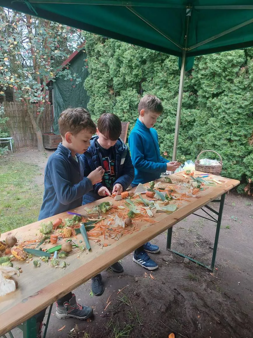 Chłopcy przygotowujący warzywa na zupę pazibrodę