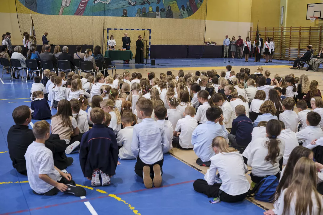 Podczas akademii w hali sportowej przemawia dyrektor szkoły.