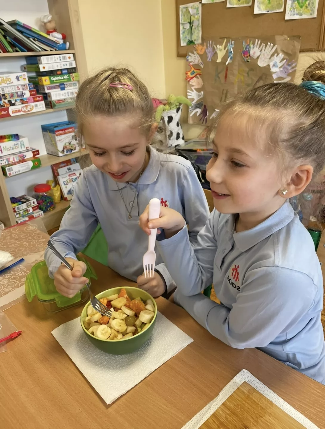 Uczennice z samodzielnie przygotowaną sałatką owocową.