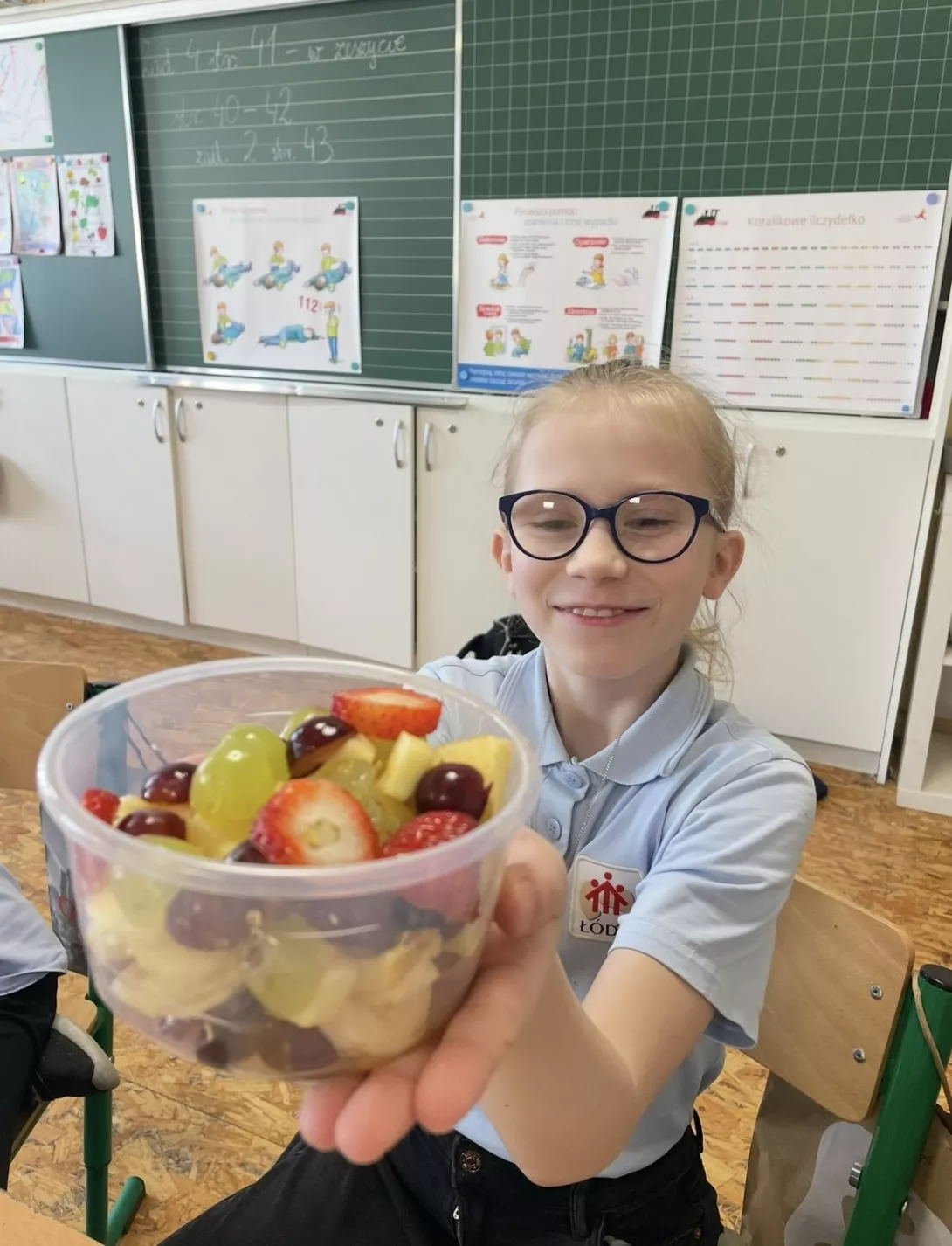 Uczennica z samodzielnie przygotowaną sałatką owocową.