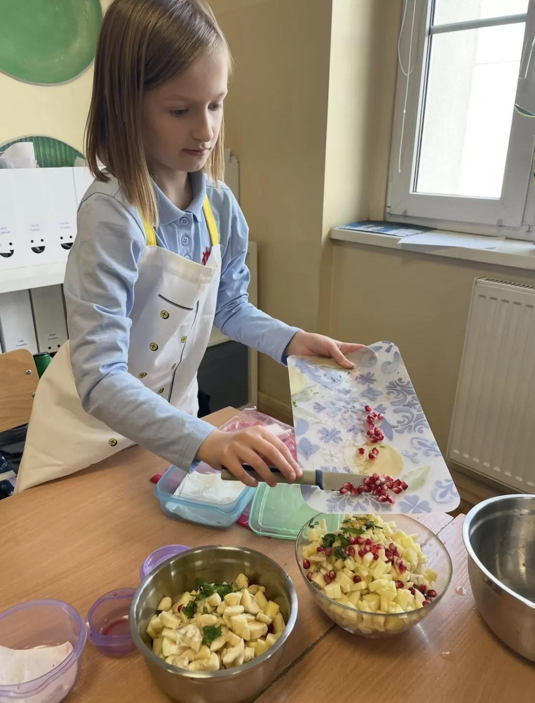 Uczennica przygotowuje sałatkę owocową.