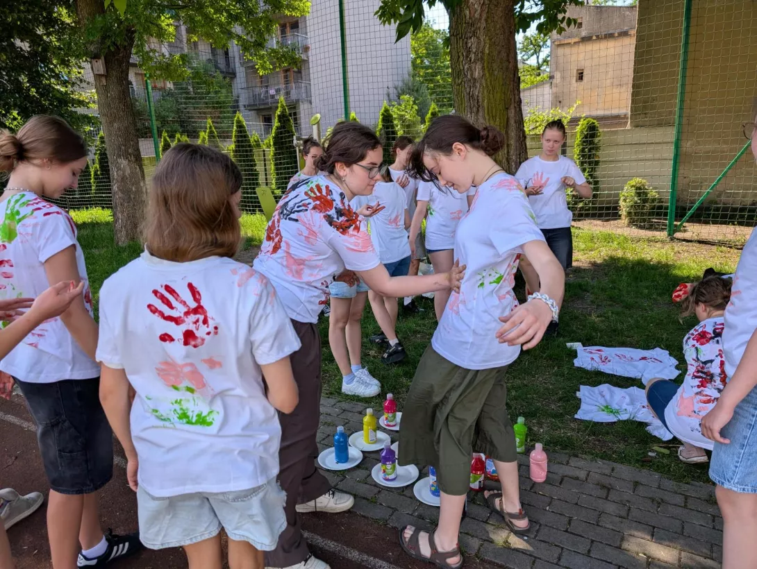 Dziewczęta odciskają dłonie na koszulkach
