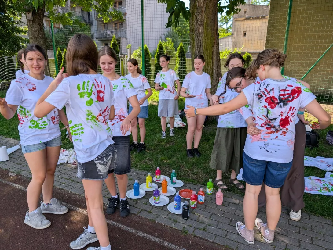 Dziewczęta odciskają dłonie na koszulkach